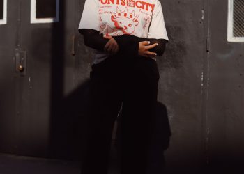 a woman standing in front of a metal door