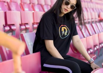 woman in black and yellow crew neck t-shirt sitting on purple chair