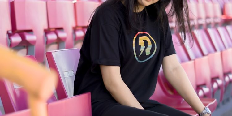 woman in black and yellow crew neck t-shirt sitting on purple chair
