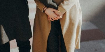 person in brown coat and black pants