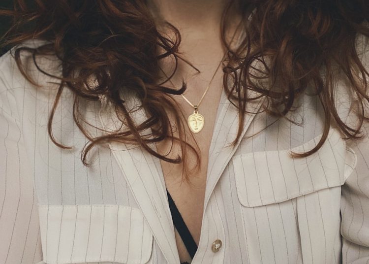 woman in white blazer with silver necklace