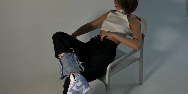 Woman sits in a chair, striking a pose.