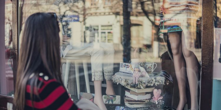 woman standing near store while looking at the mannequin