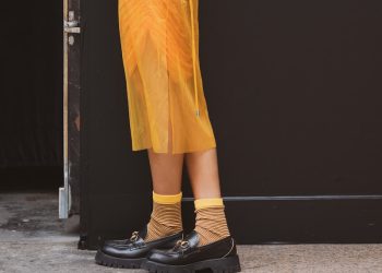 a woman in a white sweater and yellow skirt