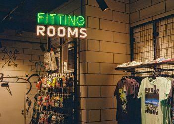 a store with a neon sign that says fitting rooms