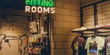 a store with a neon sign that says fitting rooms