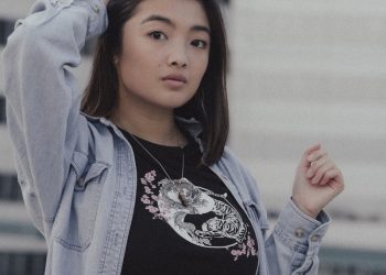 woman in black and white floral shirt and blue jacket